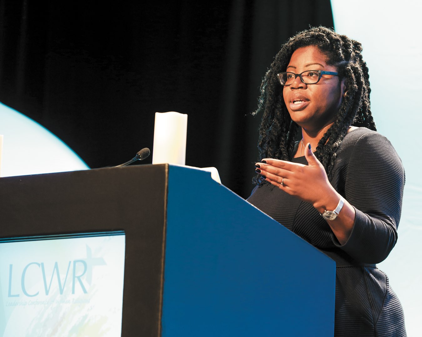 Dr. Shannen Dee Williams standing behind a conference podium giving a talk