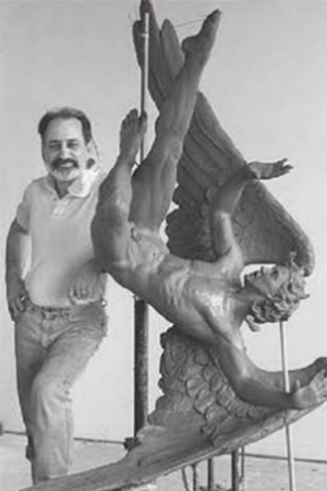 An image of George Nista standing next to one of his pieces