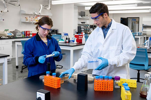 A student and a professor in an engineering lab.