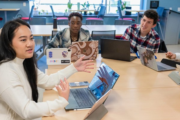 Institute for Innovation and Entrepreneurship students sitting around table with laptops talking