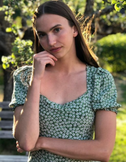 image of woman looking at camera with trees in background