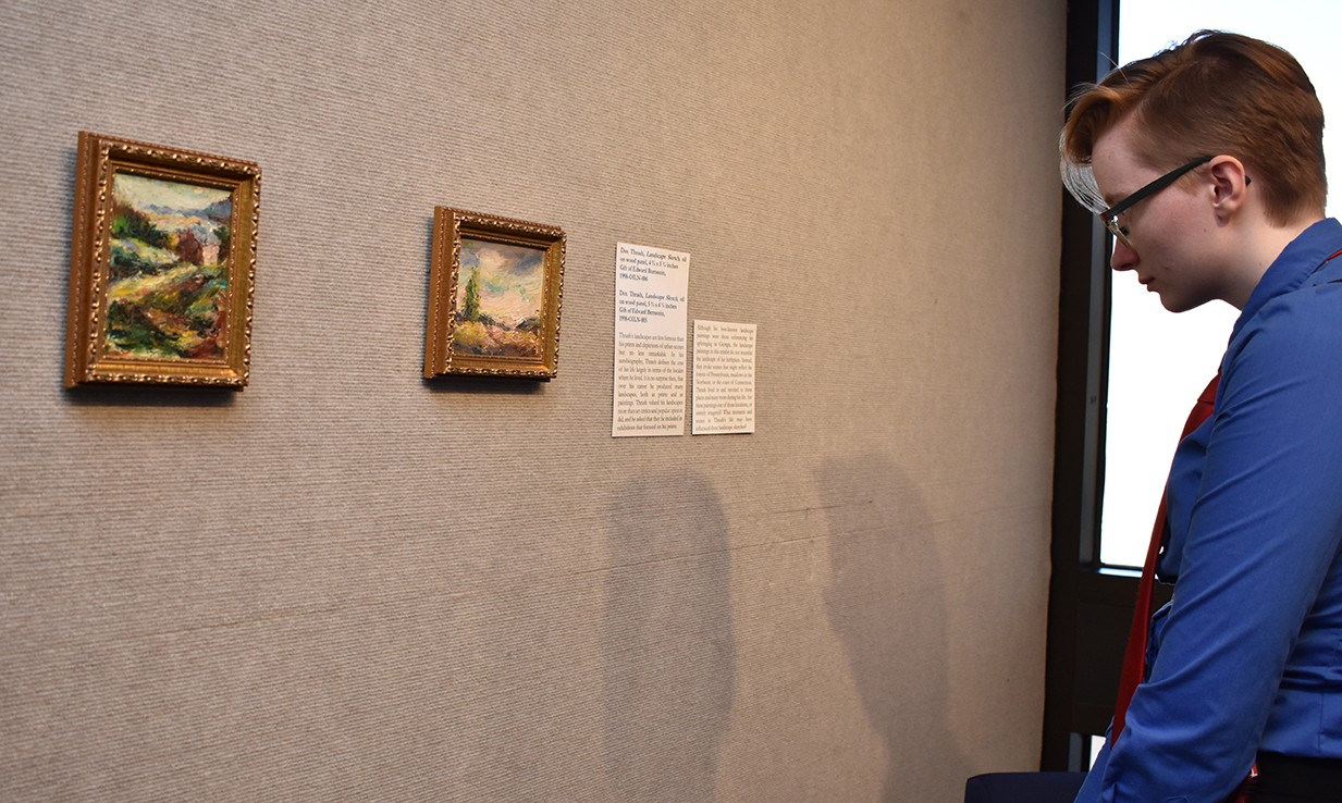 Student looking at two small paintings Student looking at two small paintings