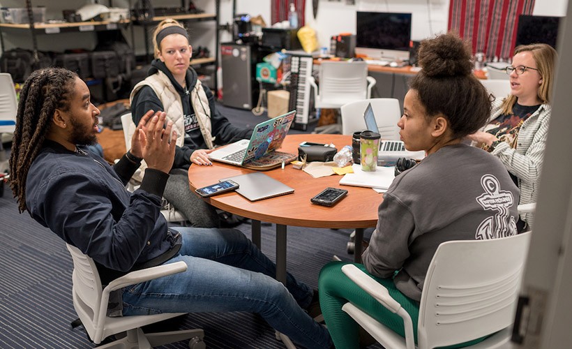 Student filmmakers sit in the editing room to discuss the project. Student filmmakers sit in the editing room to discuss the project.