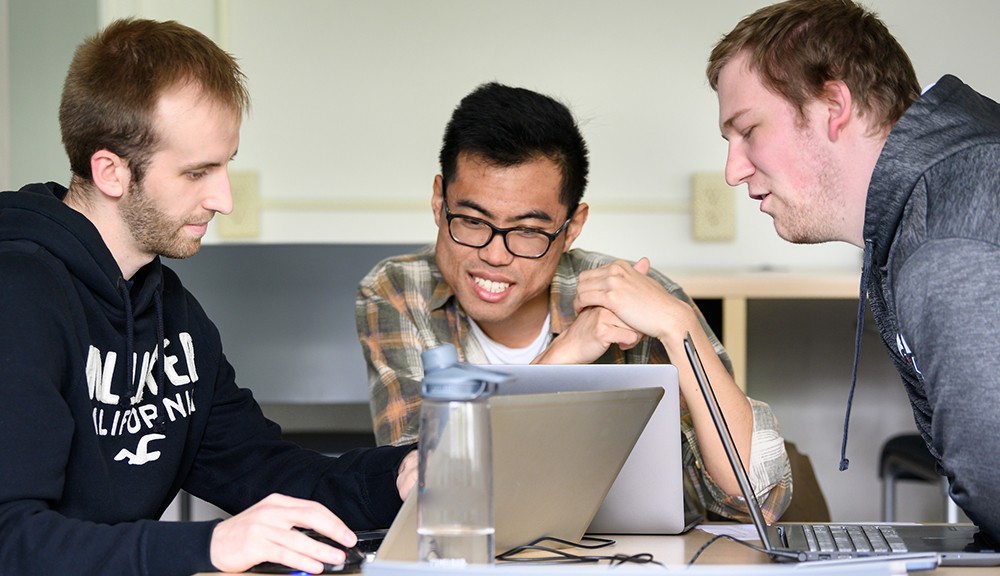 Graduate students seated at a table working on a group project