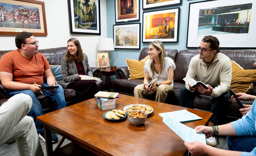 Students and faculty sit in the Humanities lounge for a discussion.