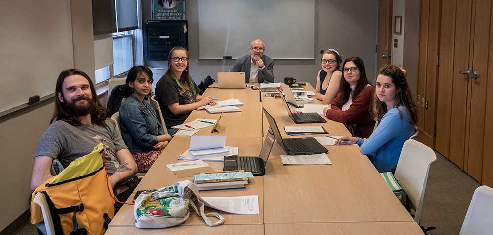Graduate students seated around a seminar table