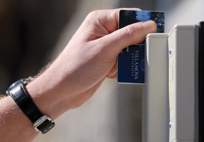 Wildcard access A hand swiping a wildcard for access into a building