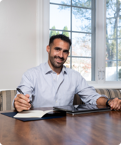 man taking notes at a table smiling at the camera