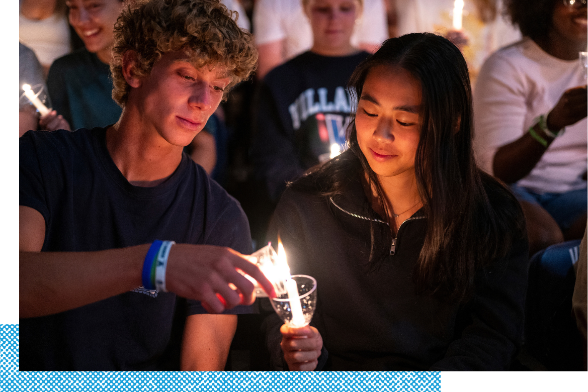 Students lighting candles during orientation.