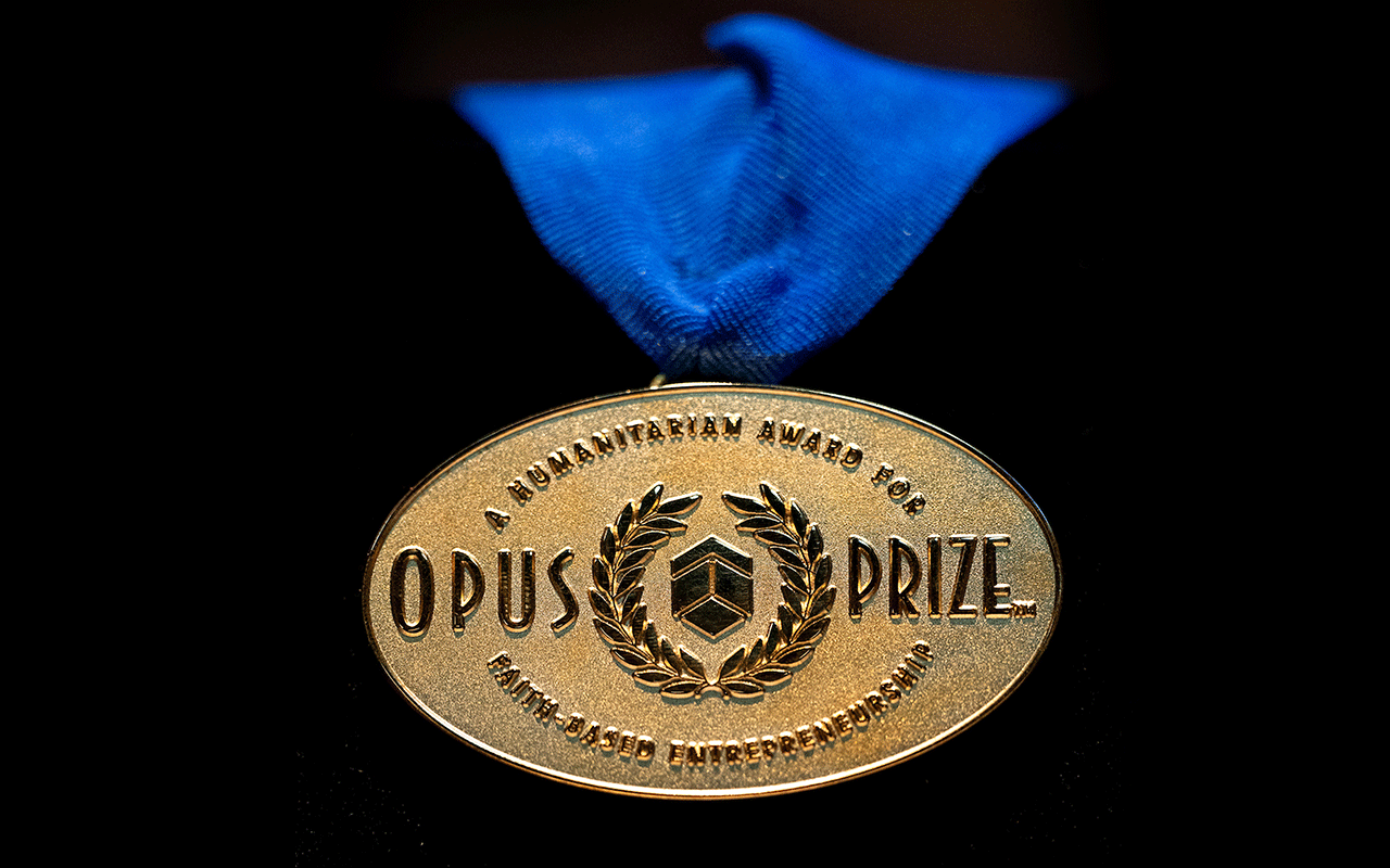 The gold Opus Prize medal hangs on a blue ribbon